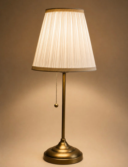 Table lamp with pleated white shade on a beige background